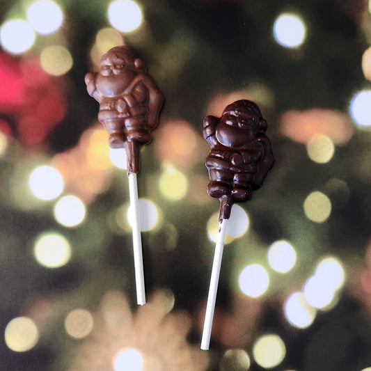 Spread a little extra holiday cheer with our Mini Santa Waving Lollipop! This bite-sized chocolate pop, crafted in the shape of a waving Santa, is the perfect festive touch for any stocking, gift bag, or holiday gathering.  Available in milk or dark chocolate