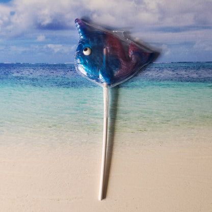 A blue raspberry and grape flavored hard candy lollipop. In the shape of the unicorn of the sea - a narwhal.