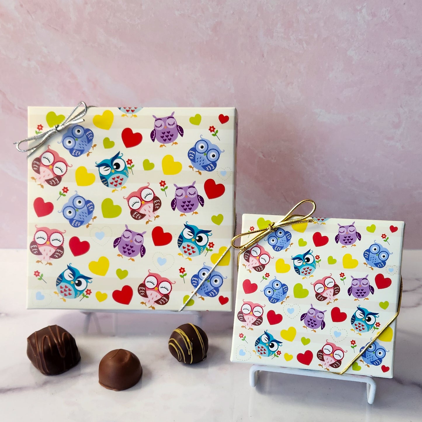 An assortment of our most popular milk and dark chocolate creams, caramels, melt-aways, and truffles all packed inside a festive box. On the cover of the box colorful Owls and Hearts are printed.