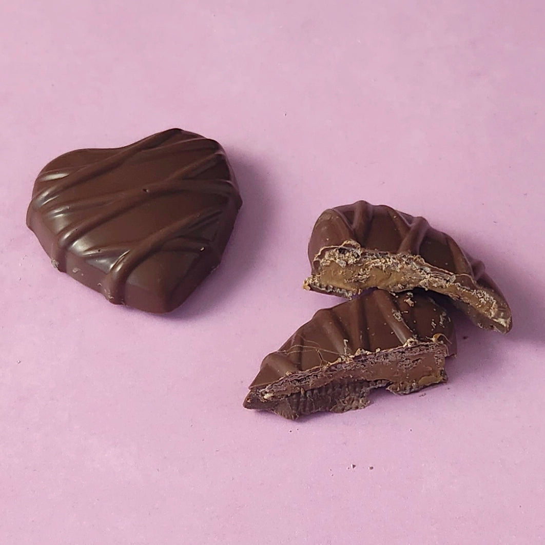 Two chocolate candies on a light purple background
