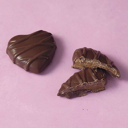Two chocolate candies on a light purple background