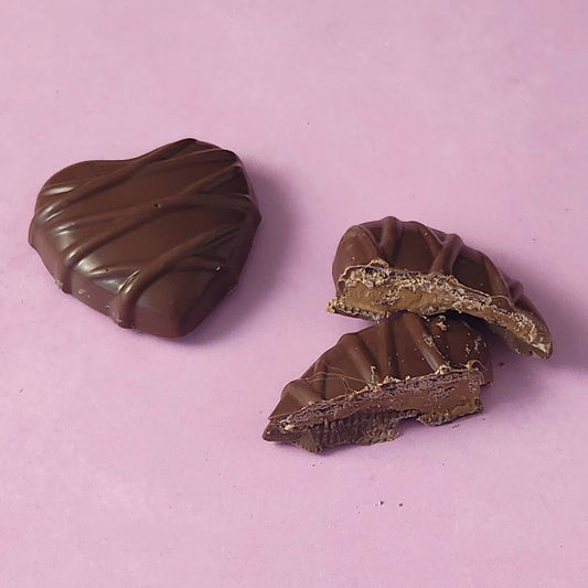 Two chocolate candies on a light purple background