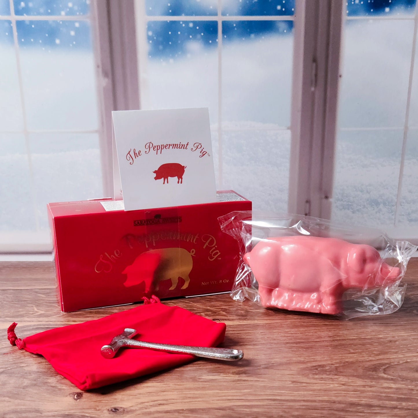 Experience the joy of a cherished holiday tradition with the Peppermint Pig, made by Saratoga Sweets! This delightful 8-ounce peppermint treat comes beautifully packaged with a story card detailing its festive history, a velvet bag, and a small hammer to break the pig into shareable pieces. Symbolizing prosperity, health, and happiness for the coming year, the Peppermint Pig is perfect for family gatherings or as a unique and thoughtful holiday gift