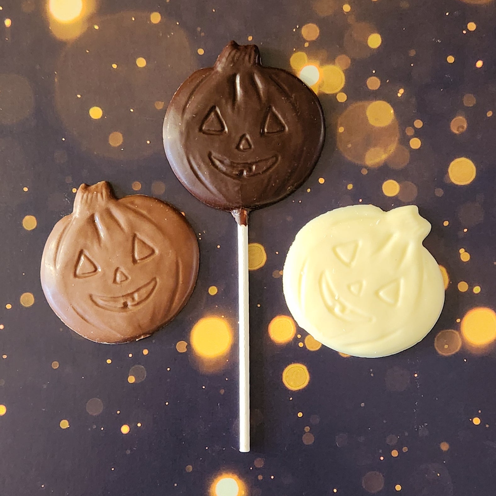 Milk, dark or white Chocolate Jack-o-lantern lollipops and favors.  Each handcrafted pumpkin face measures approximately 2.75 inches wide by 2.75 inches tall (not counting the lollipop stick!)