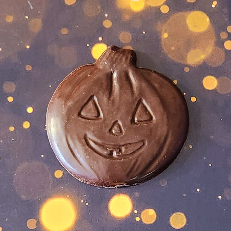 Dark Chocolate Jack-o-lantern favor.  Each handcrafted pumpkin face measures approximately 2.75 inches wide by 2.75 inches tall