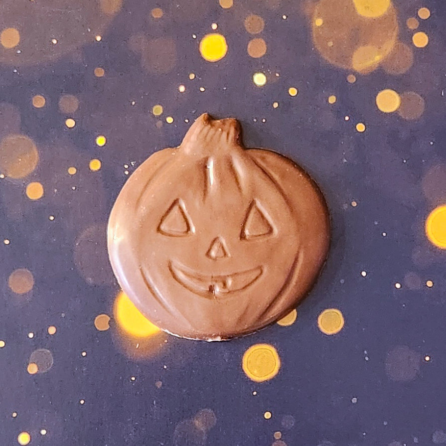 Milk Chocolate Jack-o-lantern favor.  Each handcrafted pumpkin face measures approximately 2.75 inches wide by 2.75 inches tall