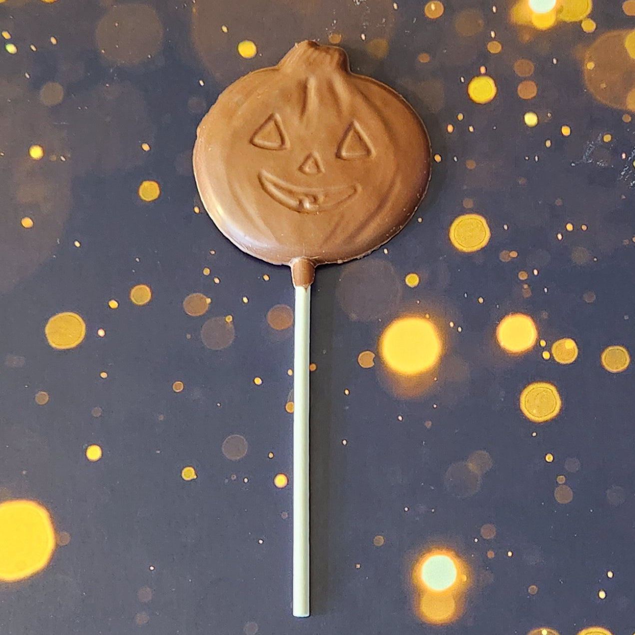 Milk Chocolate Jack-o-lantern lollipop.  Each handcrafted pumpkin face measures approximately 2.75 inches wide by 2.75 inches tall (not counting the lollipop stick!)