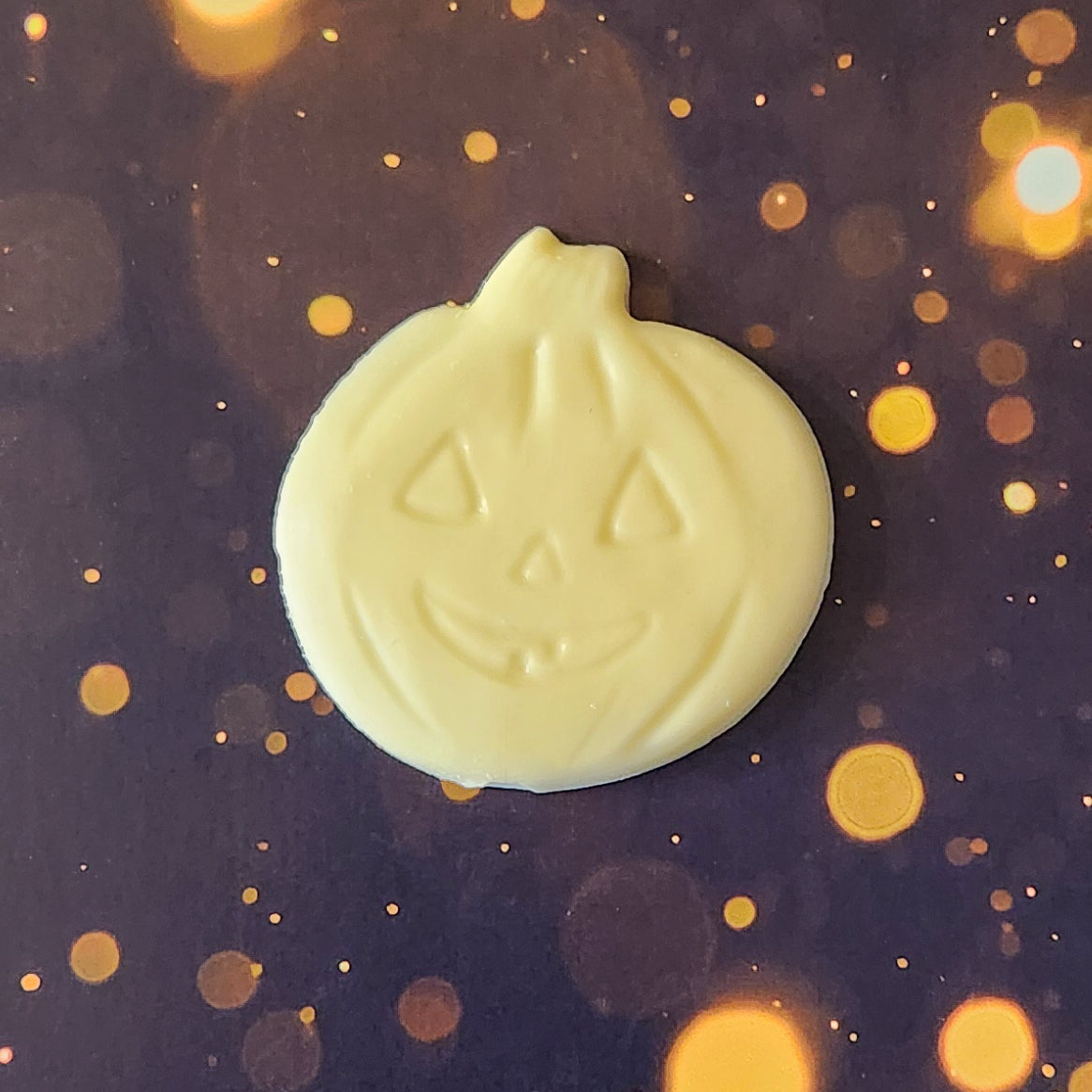 White Chocolate Jack-o-lantern favor.  Each handcrafted pumpkin face measures approximately 2.75 inches wide by 2.75 inches tall