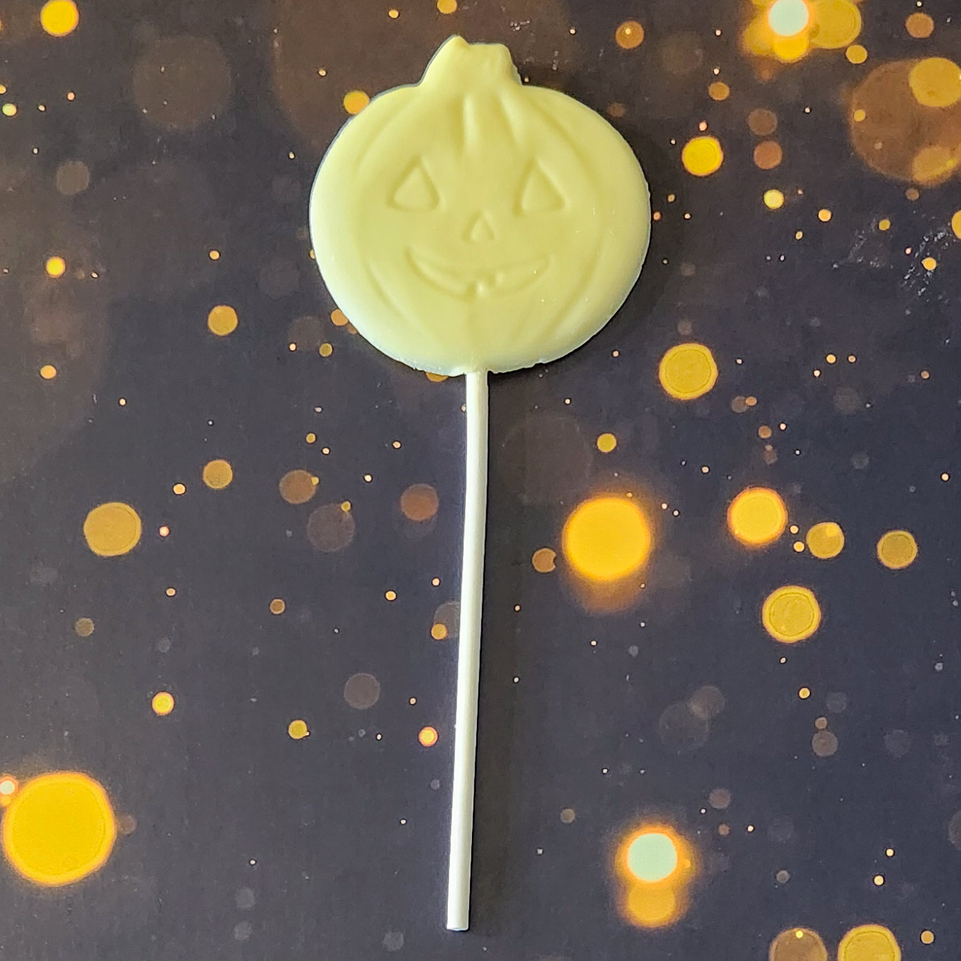 White Chocolate Jack-o-lantern lollipop.  Each handcrafted pumpkin face measures approximately 2.75 inches wide by 2.75 inches tall (not counting the lollipop stick!)