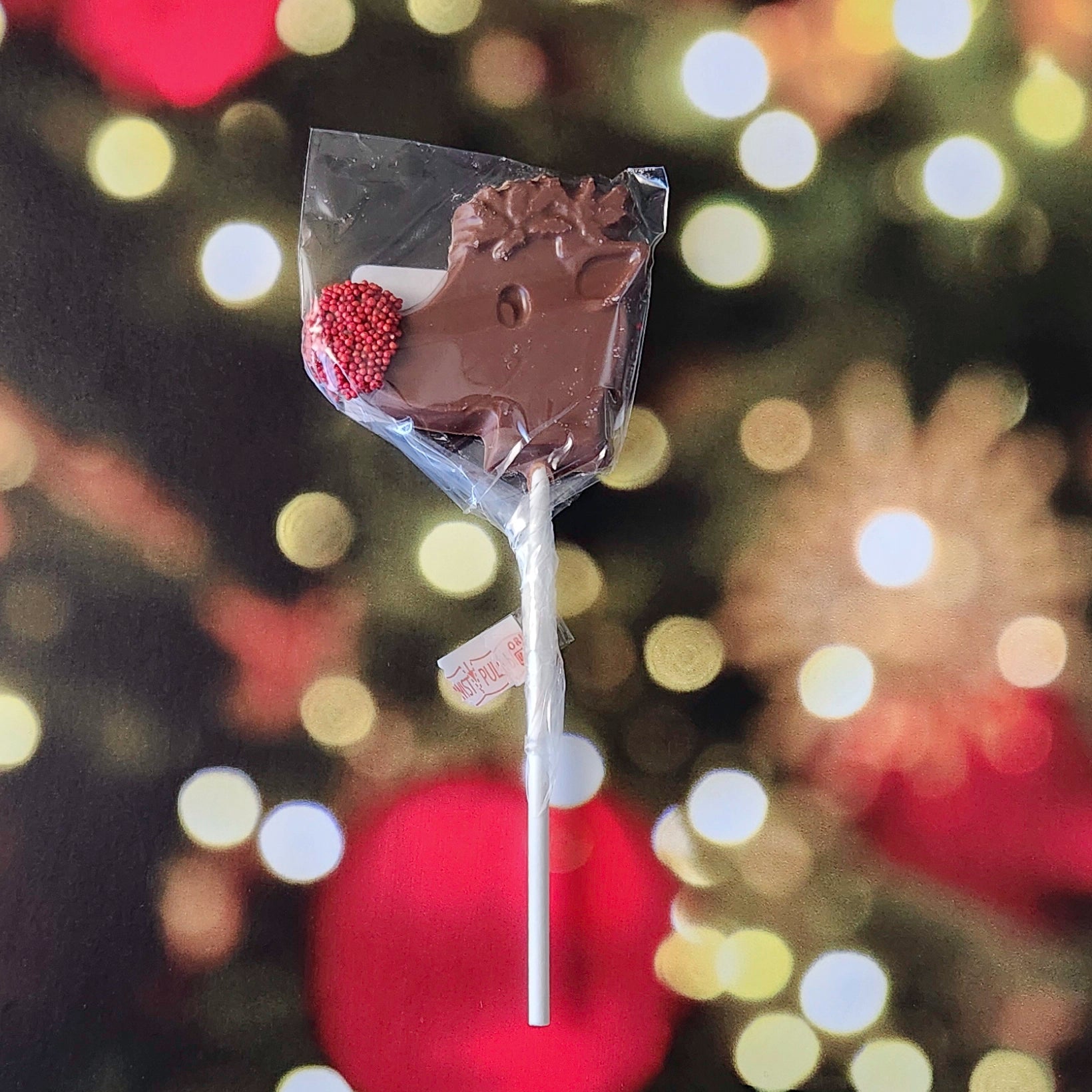 Bring some holiday magic to your candy lineup with our Rudolph Lollipop! Made from creamy Milk Chocolate, this festive lollipop is shaped like everyone’s favorite reindeer and features Rudolph’s famous red nose, decorated with cheerful red nonpareils for a fun, playful touch