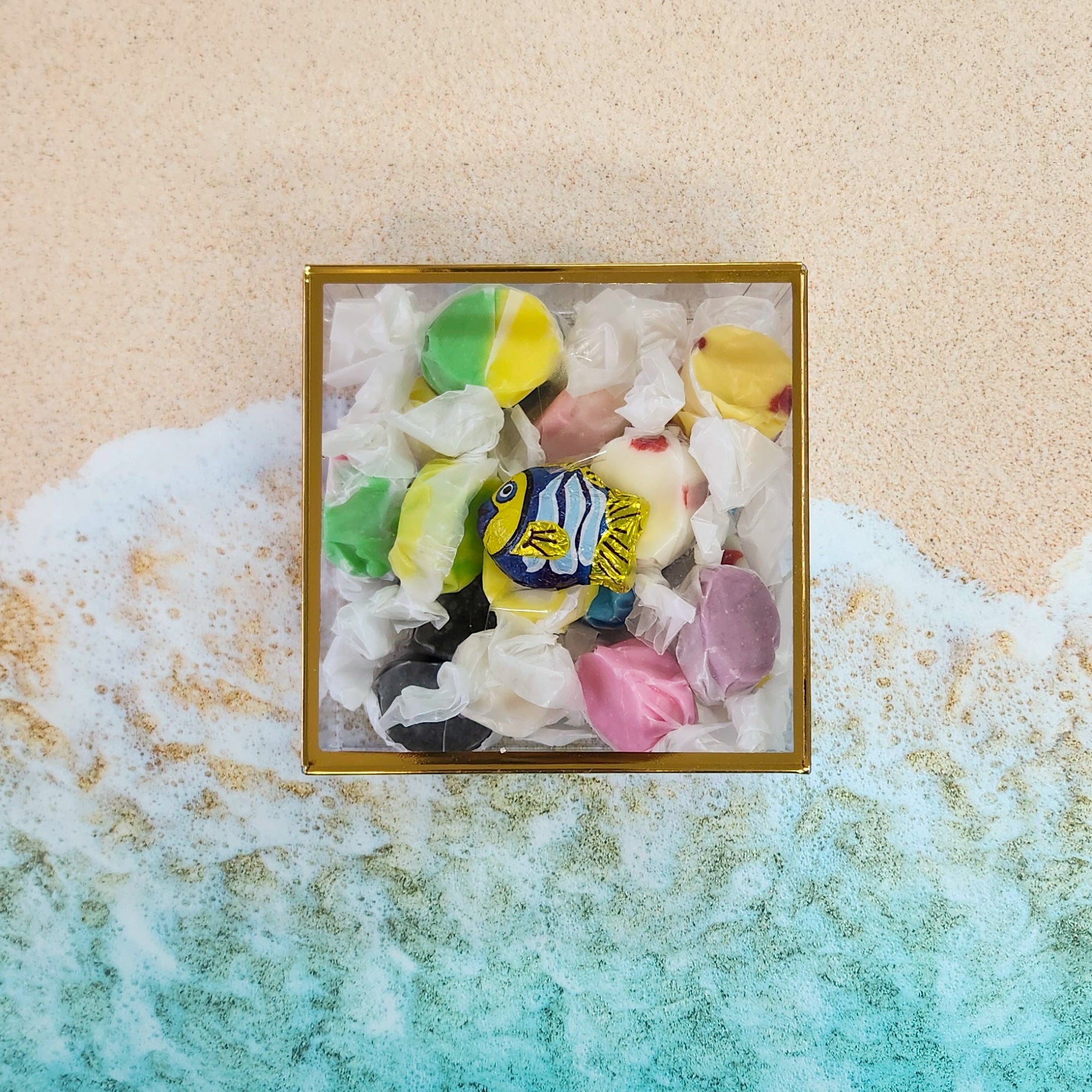 Inside this cheerful gift box, you’ll find 6 ounces of our signature salt water taffy, bursting with nostalgic flavors like strawberry, lemon, orange, and more.  Tucked beside the taffy is a whimsical bite-sized milk chocolate fish, wrapped in bright foil and ready to make waves. 
