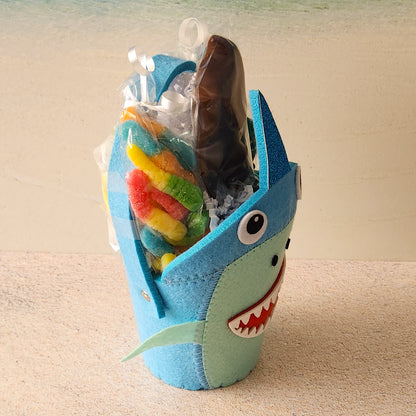Sour Gummi Worms, Baby Gummy Sharks, Sweet Salt Water Taffy and a Milk Chocolate Shark Pop fill this fun themed gift basket.