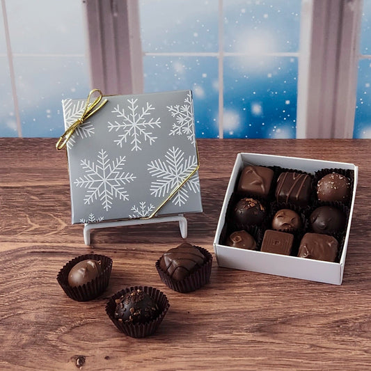 Box of chocolates with a decorative box on a wooden surface