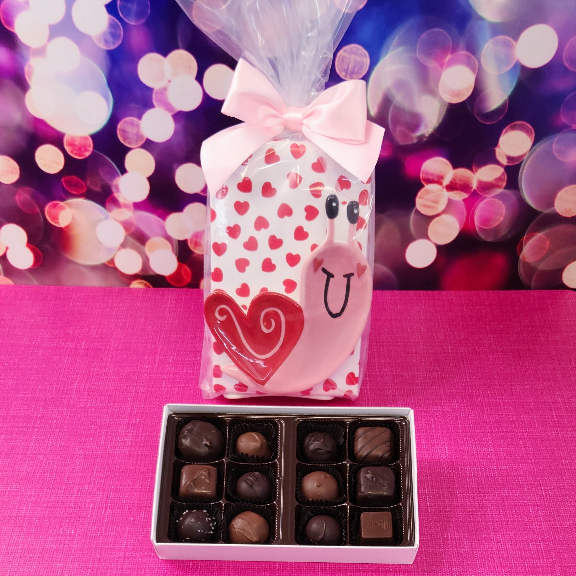 ½ Layer Milk & Dark Chocolate Popular Assortment.  A delightful mix of our best-selling chocolates, including smooth creams, chewy caramels, crunchy nut clusters, and melt-in-your-mouth truffles. Wrapped in festive Valentine’s heart paper.  Comes with an  adorable Snail with Heart Shell Candy Plate