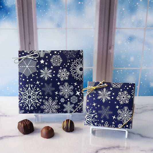 An assortment of our most popular milk and dark chocolate creams, caramels, melt-aways, and truffles all packed inside a box with an elegant snowflake pattern on the cover.