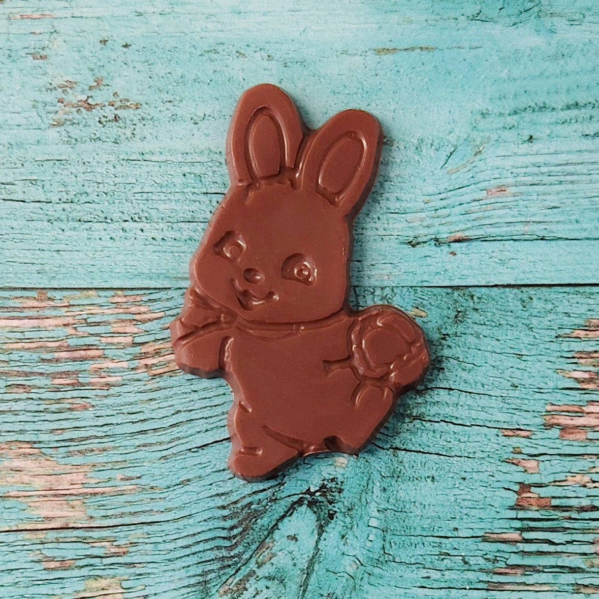 Chocolate bunny on a textured blue wooden surface