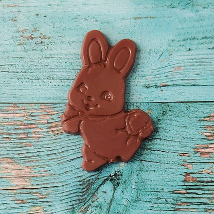 Chocolate bunny on a textured blue wooden surface