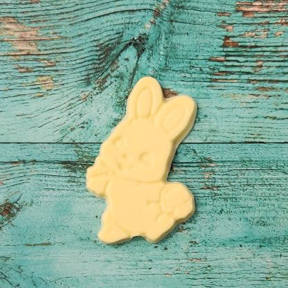 White chocolate bunny on a textured blue wooden surface