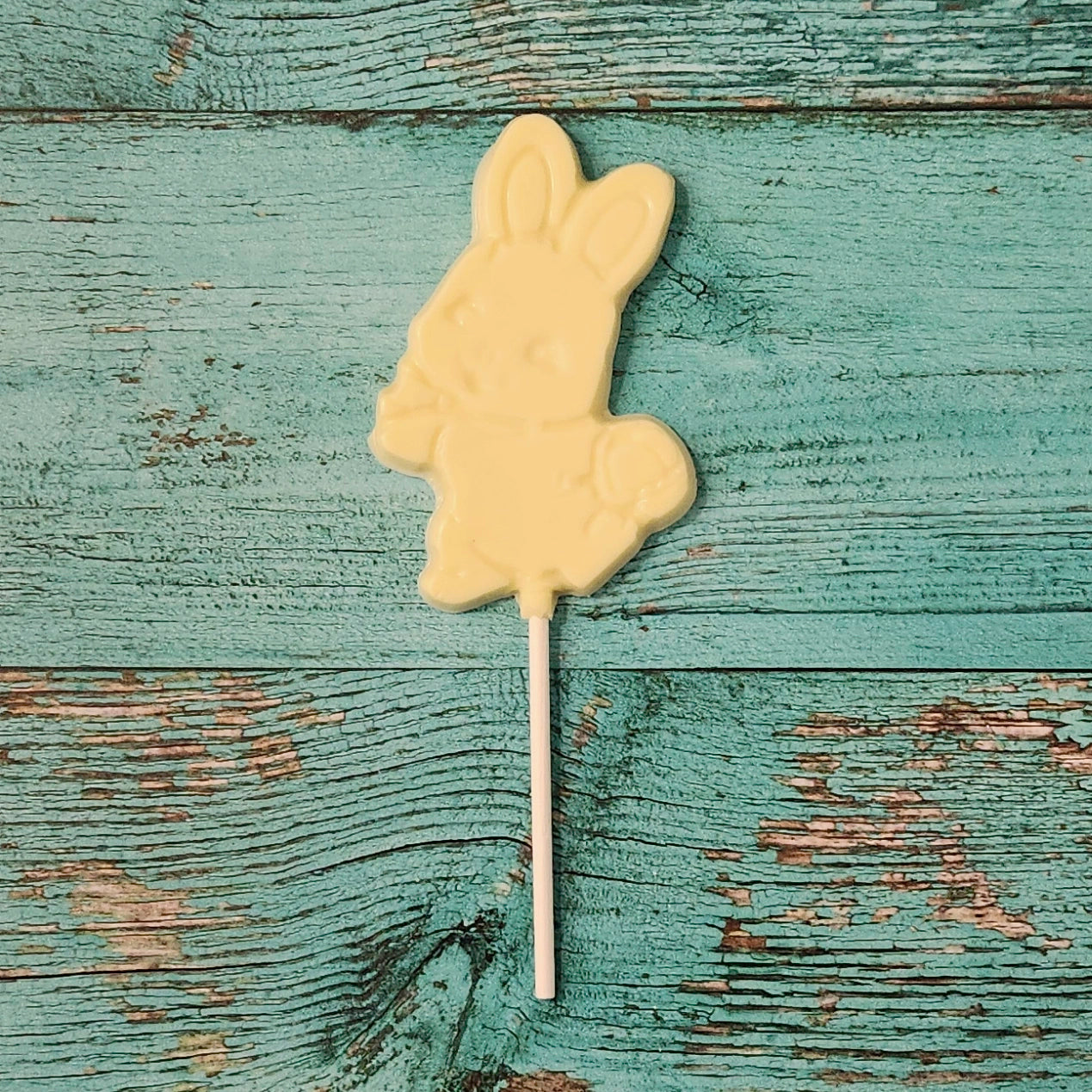 White Chocolate bunny-shaped lollipop on a wooden surface