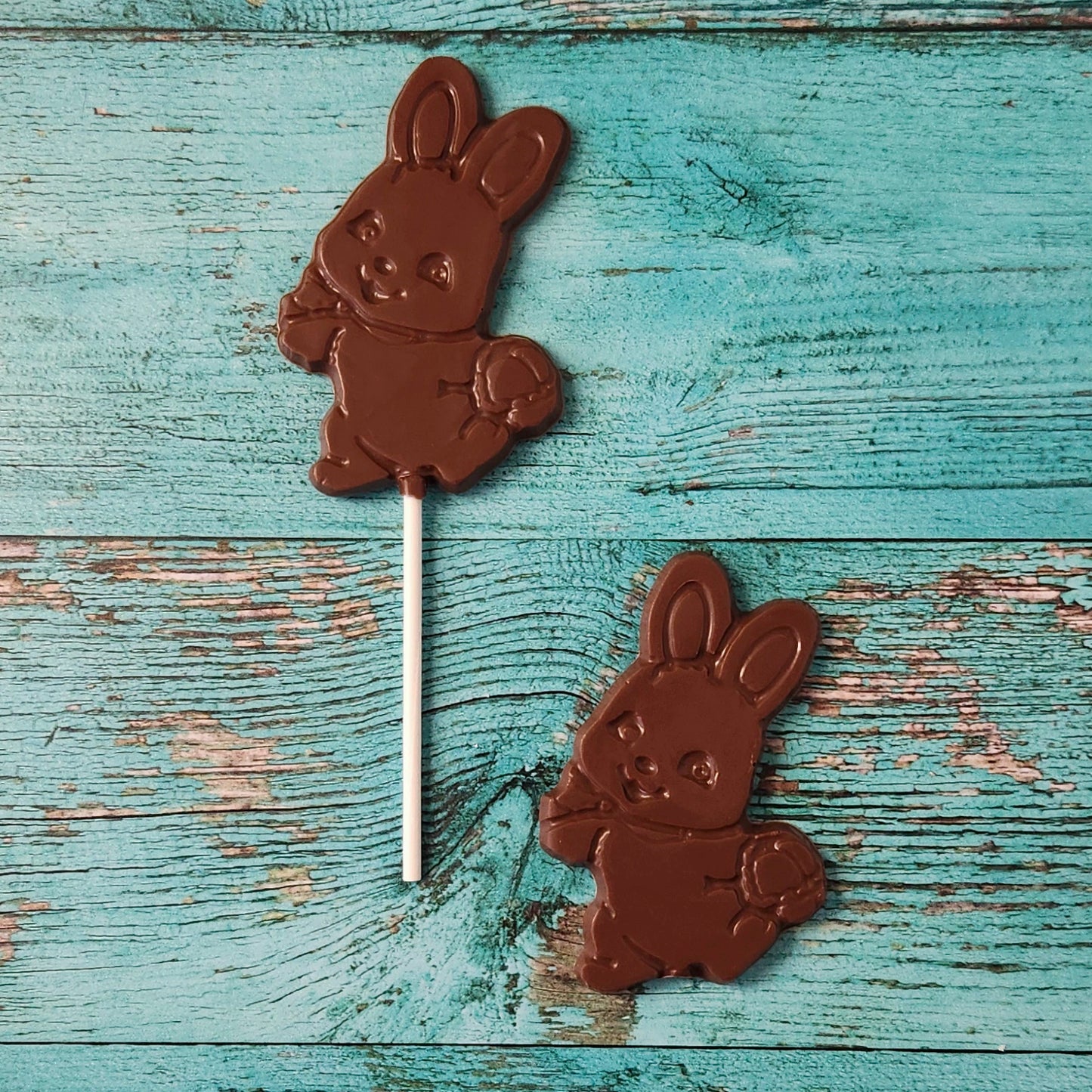 Chocolate bunny lollipops on a wooden surface