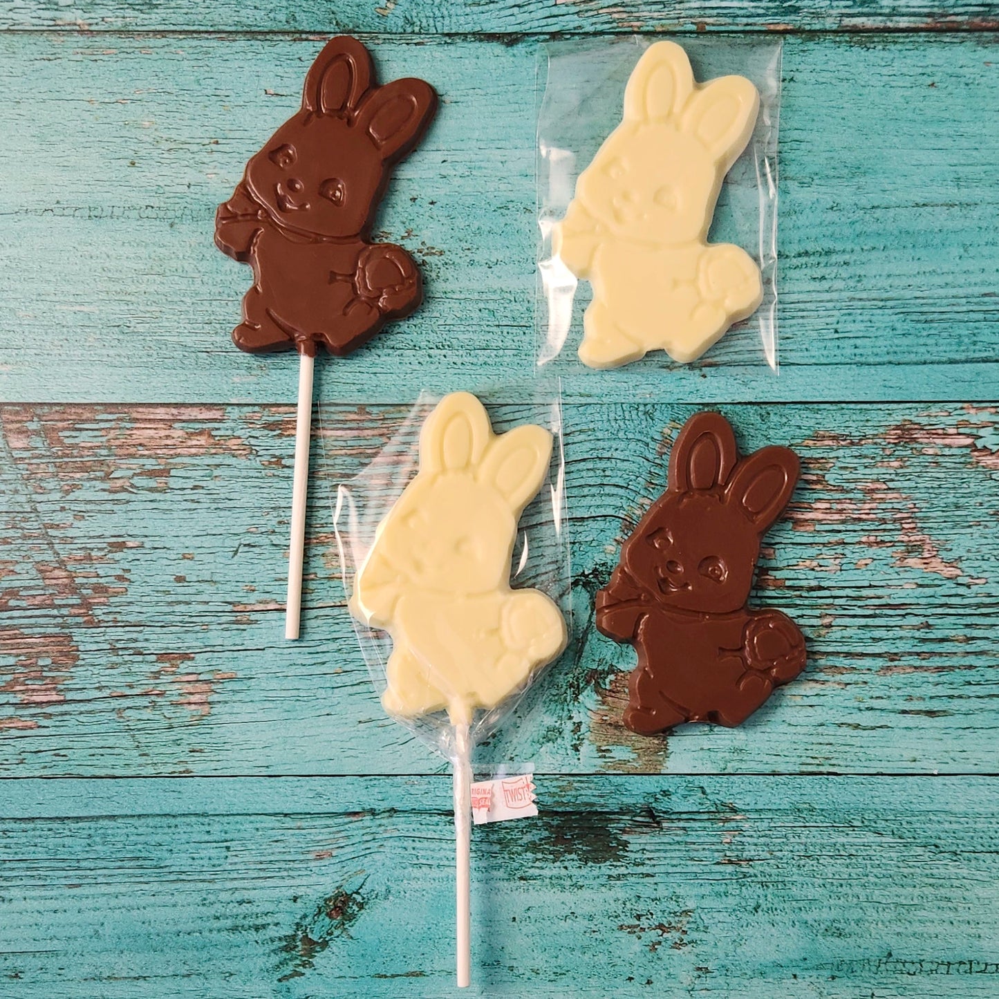 Chocolate and white bunny lollipops on a rustic wooden surface