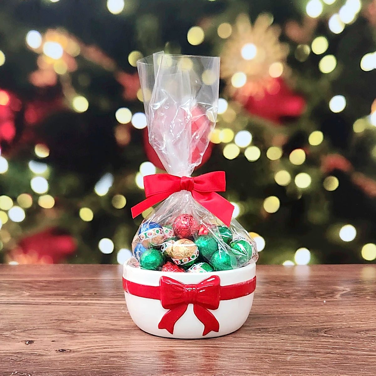 Sweet Tidings Candy Dish, the Red Bow bowl, front view, filled with foil-wrapped chocolates bagged with a red bow