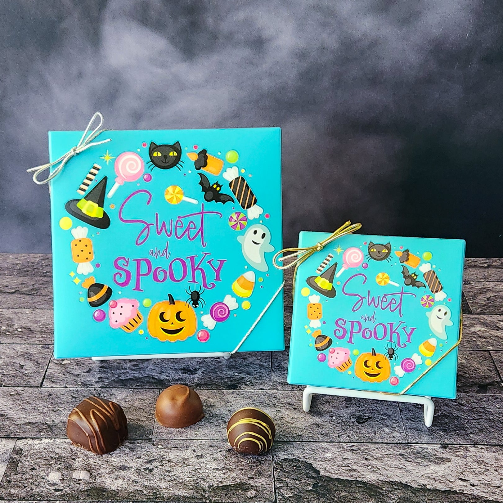 An assortment of our most popular milk and dark chocolate creams, caramels, melt-aways, and truffles all packed inside a box with the words Sweet and Spooky surrounded by candy, a black cat, a bat, a ghost, a witches hat and a pumpkin printed on the cover.