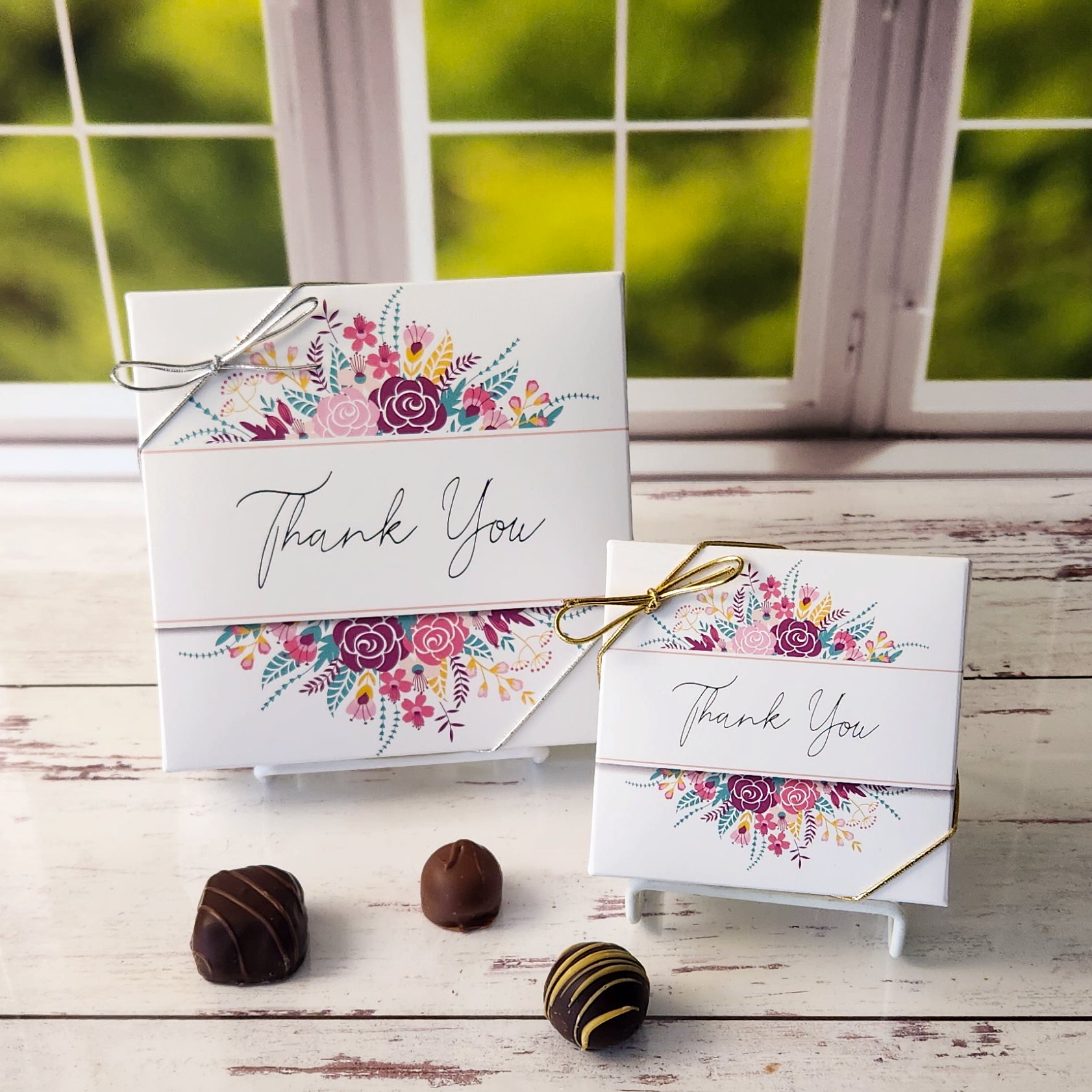 An assortment of our most popular milk and dark chocolate creams, caramels, melt-aways, and truffles all packed inside a box with the words Thank You surrounded by flowers printed on the cover