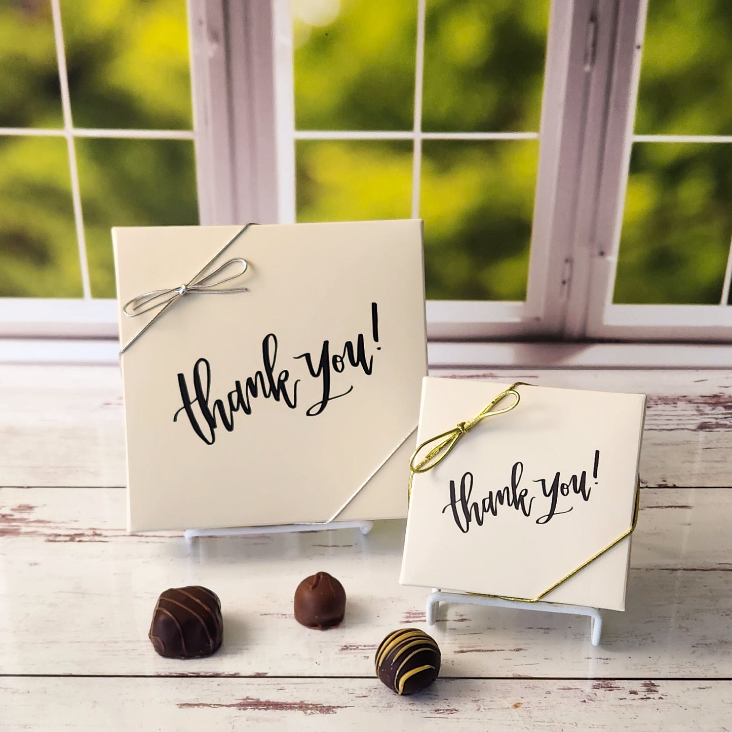 An assortment of our most popular milk and dark chocolate creams, caramels, melt-aways, and truffles all packed inside a box with the words Thank You written in script.