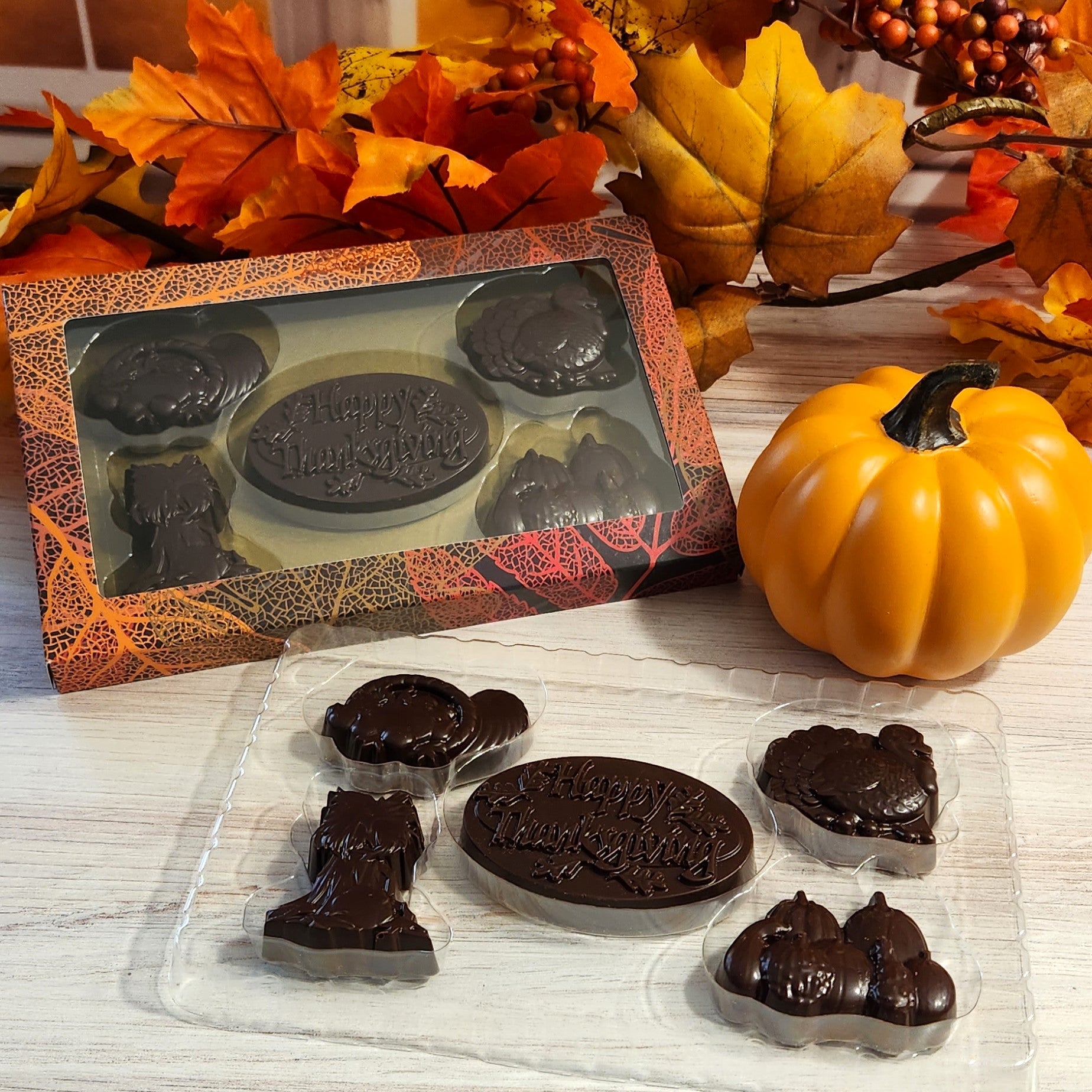 Enjoy a selection of festive dark chocolates including Cornucopia, Turkey, Pumpkin, Harvest Stalks, and a 'Happy Thanksgiving' medallion