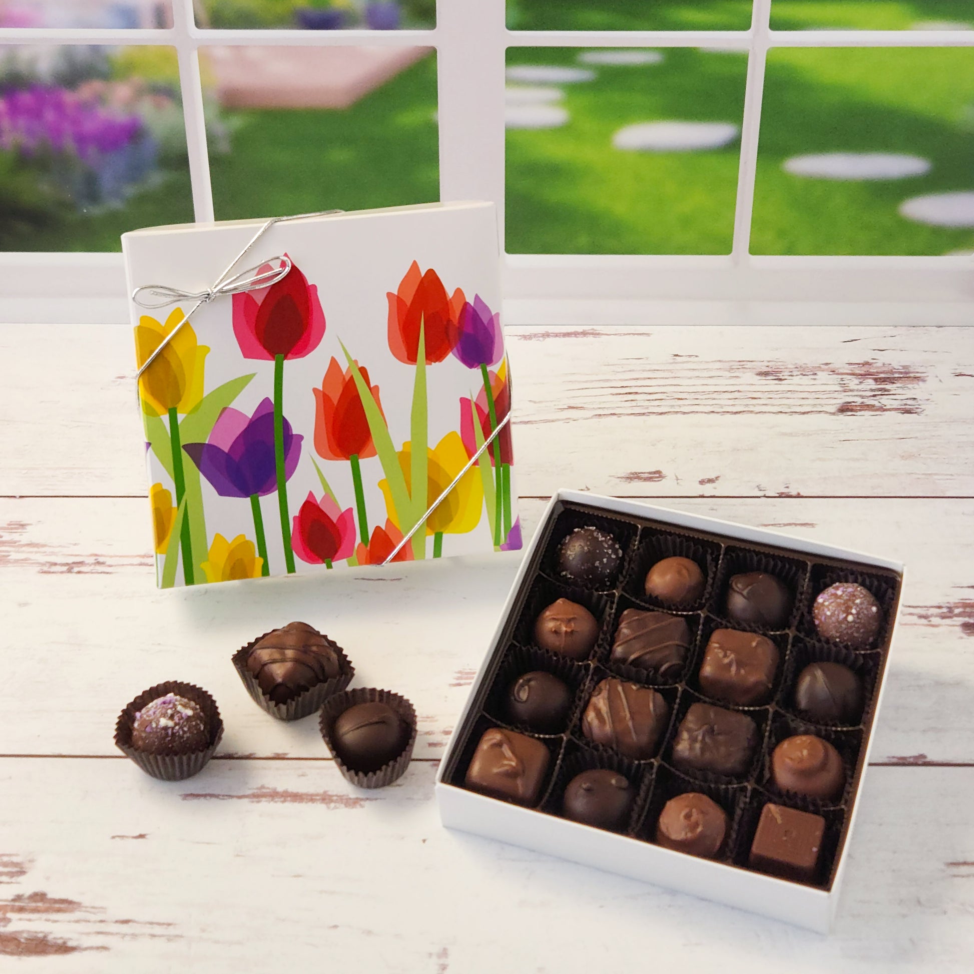 Say it with flowers—and chocolate! Our  16 piece Tulips Chocolate Box is a delightful way to brighten someone’s day with a beautiful blend of sights and tastes. Featuring a cheerful tulip design on the cover, this box is packed with Stage Stop Candy’s popular assortment of milk and dark chocolates. Handcrafted in small batches at our family-run Cape Cod shop, each piece is made with care to deliver that fresh, irresistible flavor we’re known for.