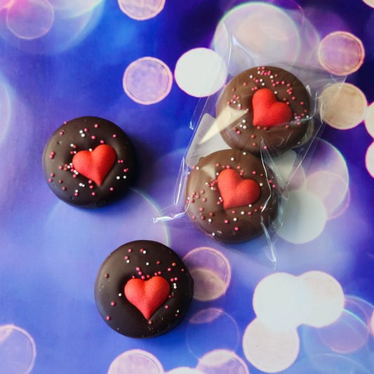 Valentine’s Day Themed Oreos.
Each Oreo is dipped in creamy milk or rich dark chocolate, then topped with festive sprinkles and a sugar heart to spread the Valentine’s Day cheer. Perfectly portioned in a 2-pack, these sweet delights are ready to brighten someone’s day!