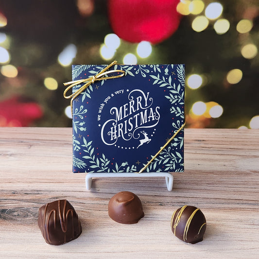 An assortment of our most popular milk and dark chocolate creams, caramels, melt-aways, and truffles all packed inside a box with the saying "We Wish You A Very Merry Christmas" printed on the cover.