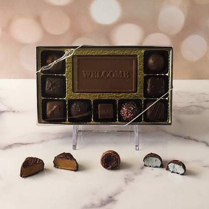 Give a warm greeting with our 9-piece Welcome Candy Box! Inside, a beautifully crafted milk chocolate card that says "Welcome" is surrounded by a delicious assortment of milk and dark chocolate soft center creams, indulgent truffles, and rich caramels. It's the perfect way to make anyone feel truly special and appreciated!