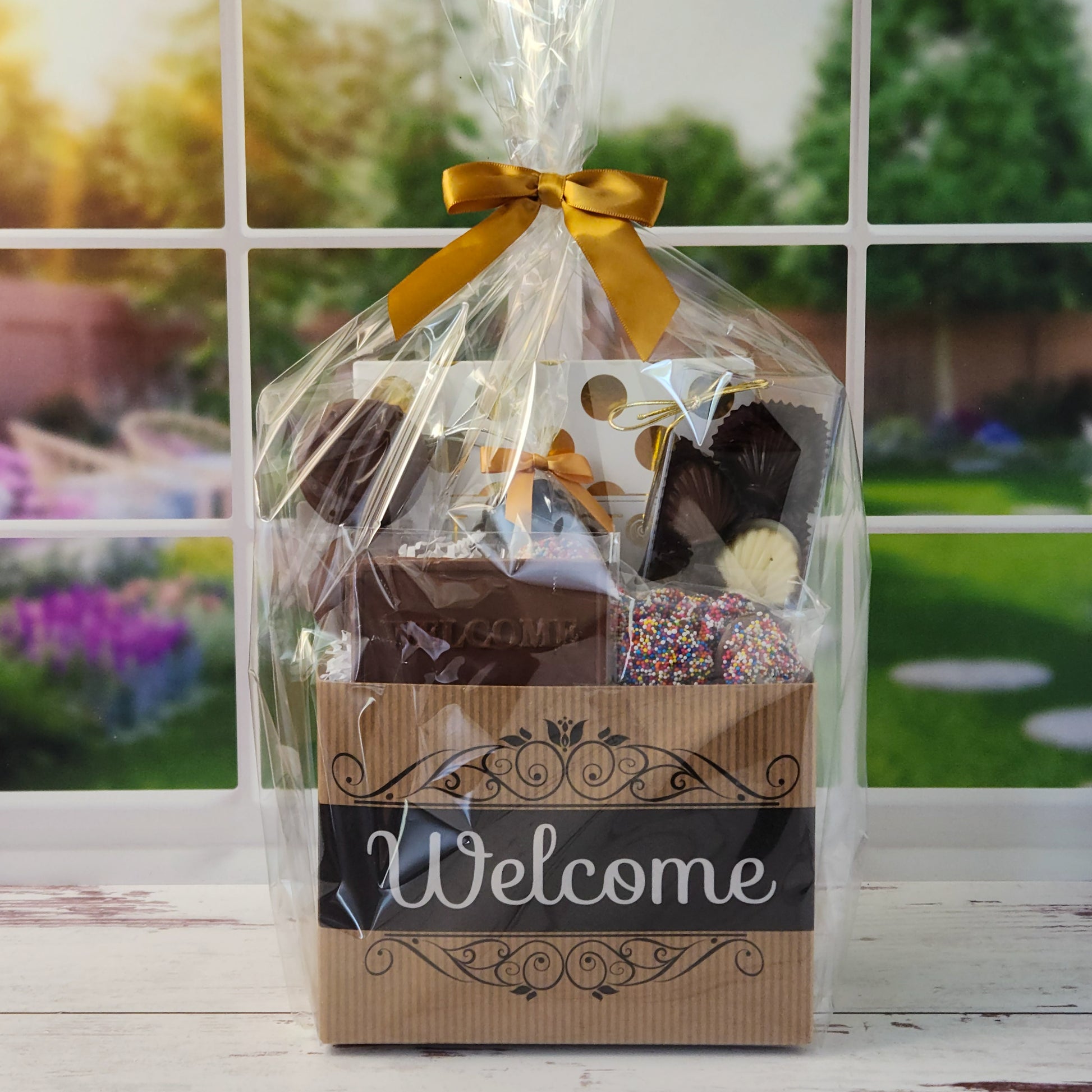 Our Welcome Gift Basket is filled with thoughtful treats  including: 
Milk, Dark & White Chocolate Sea Shells,  Milk Chocolate Nonpareils,  Dark Chocolate Covered Cranberries,  Two Chocolate Covered Oreos, a "Welcome" Milk Chocolate Bar and a 16-Piece Chocolate Assortment – filled with creams, caramels, meltaways, and truffles.  All overwrapped with a bow and ready for gifting.
