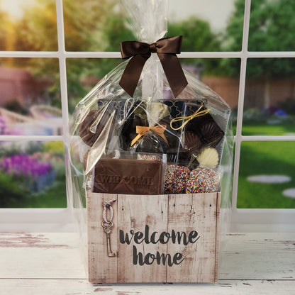 Our Welcome Home Gift Basket is filled with thoughtful treats  including: 
Milk, Dark & White Chocolate Sea Shells,  Milk Chocolate Nonpareils,  Dark Chocolate Covered Cranberries,  Two Chocolate Covered Oreos, a "Welcome" Milk Chocolate Bar and a 16-Piece Chocolate Assortment – filled with creams, caramels, meltaways, and truffles.  All overwrapped with a bow and ready for gifting.