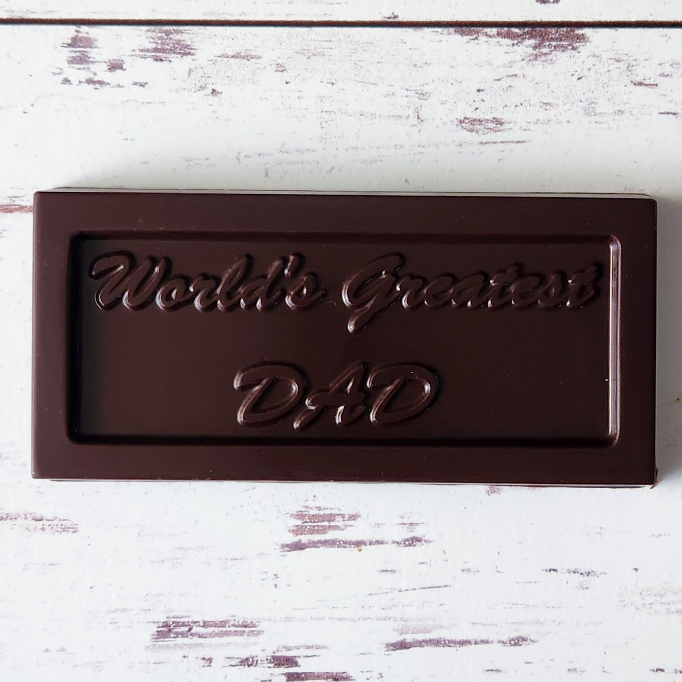 A Dark Chocolate Candy Bar with the words "World's Greatest Dad" imprinted on it. A fun gift for Dad this Father's Day.