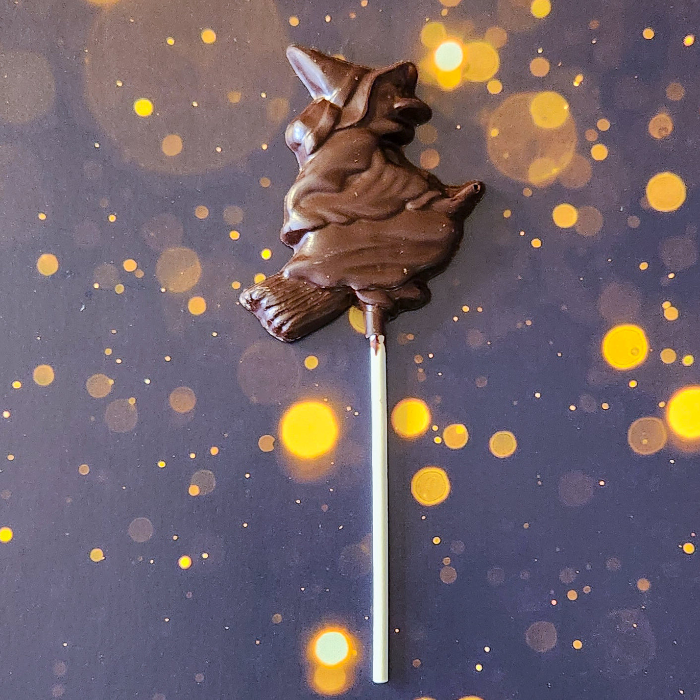 Dark chocolate witch lollipop.
measuring approximately 2.75 inches wide by 3.5 inches tall (not including the lollipop stick) and weighing around 31 grams, just the right size for a deliciously spooky snack. 