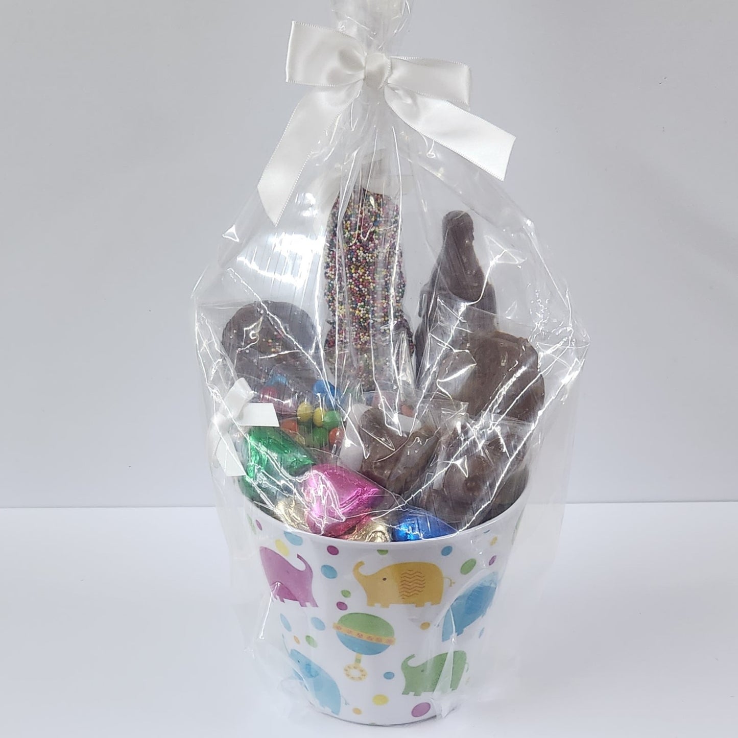 Babu Gift Basket featuring chocolate treats wrapped in plastic with a white bow