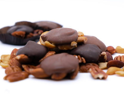 Closeup of Chocolate Caramel Nut Clusters featuring freshly roasted nuts (almonds, cashews, or pecans), held together with our delicious vanilla caramel and then topped with chocolate