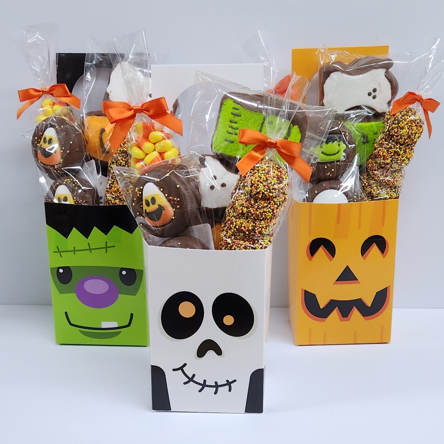 Trio of Stage Stop Candy Door Hangers featuring Candy Corn, Milk Chocolate Nonpareils, Milk Chocolate Oreos dressed up with a Halloween sugar decoration, and Chocolate Covered Peeps
