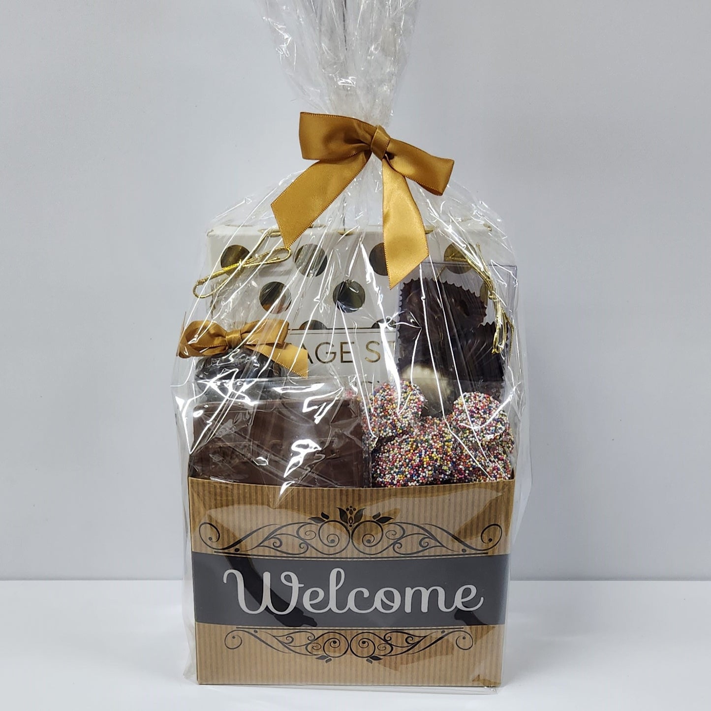 Chocolate Welcome Gift Basket wrapped in plastic with gold bow from Stage Stop Candy in Dennisport, MA