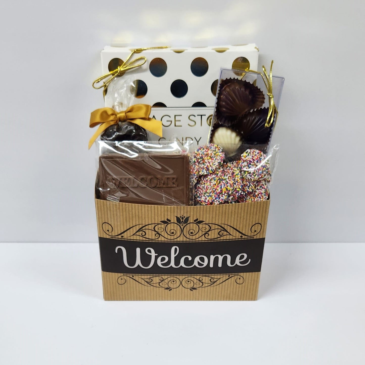 Chocolate Welcome Basket includes milk, dark and white chocolate sea shells, crunchy milk chocolate nonpareils, savory dark chocolate covered cranberries, and a 16 piece chocolate assortment filled with creams, caramels, meltaways and truffles.