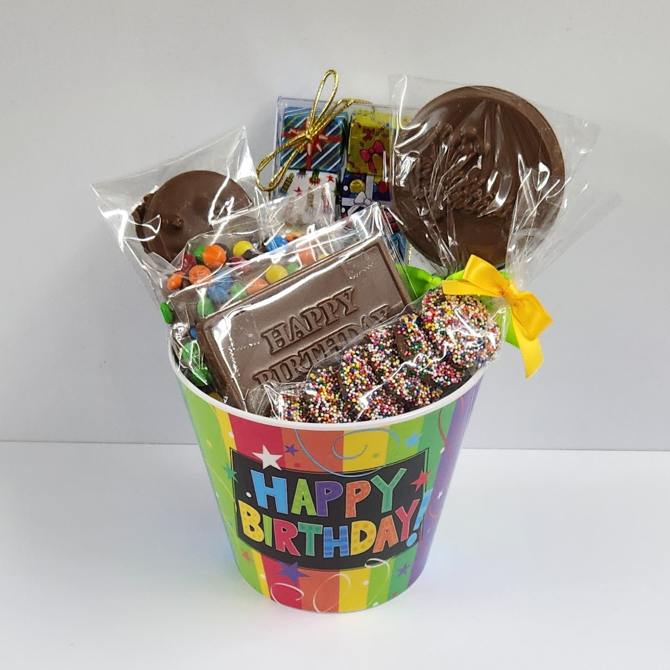 Happy Birthday Chocolate Gift Basket includes foiled milk chocolate presents, milk chocolate nonpareils, milk chocolate M & M Pretzel, milk chocolate oreos, a milk chocolate birthday lollipop and a milk chocolate "Happy Birthday!" card
