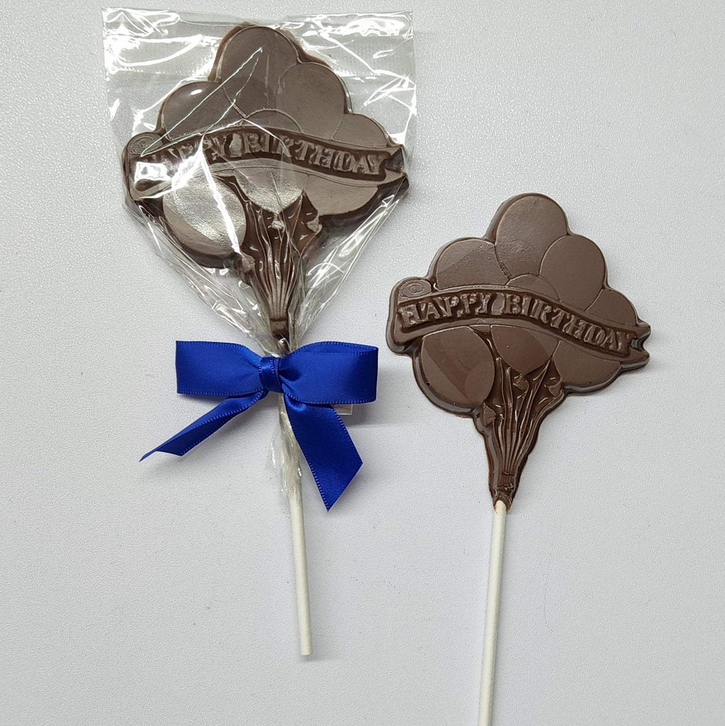 Milk chocolate lollipop with balloons and Happy Birthday banner
