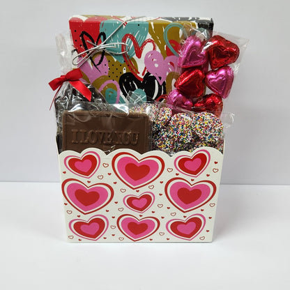 I Love You chocolate gift basket includes milk chocolate foiled hearts, milk chocolate nonpareils, a milk chocolate card that says "I LOVE YOU," dark chocolate-covered cranberries, and a 16-piece assortment including creams, caramels, meltaways, and truffles