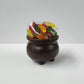 A 3D dark chocolate kettle filled with Salt Water Taffy and Gummy Worms.