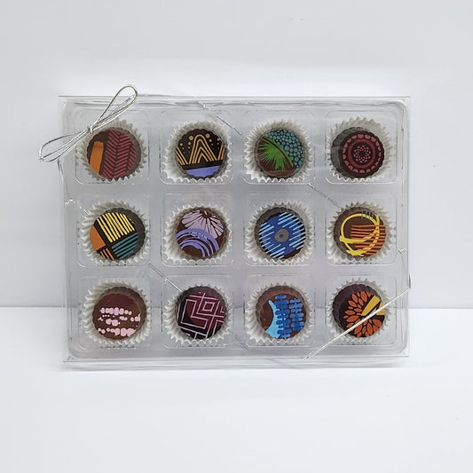 A clear plastic box displaying 12 premium chocolate truffles made by Stage Stop Candy 