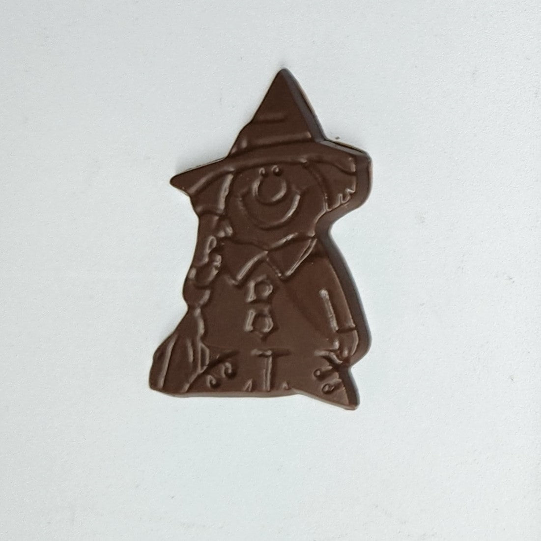 Milk chocolate witch standing with a broom
